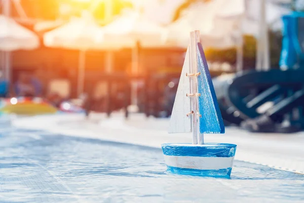 Barca a vela giocattolo in legno vicino alla piscina in estate — Foto Stock