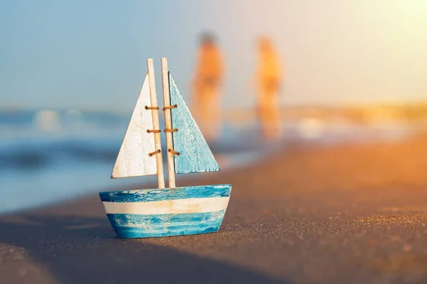 Voilier jouet en bois debout sur le sable près du bord de mer — Photo