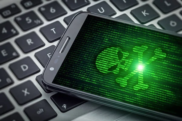 Tengkorak kematian pada layar smartphone. Hacked mobile phone on lapt — Stok Foto