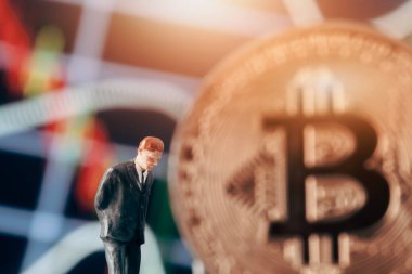 Düşünen işadamı ile kripto para kavramı: Elleri arkada olan iş adamı figürü, pazar tablosu ve bitcoin önünde karar vermeye karar veriyor. 