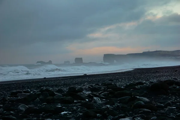 Black Rocks With Smashing Waves In The Background At Reynisfjara Beach In Iceland