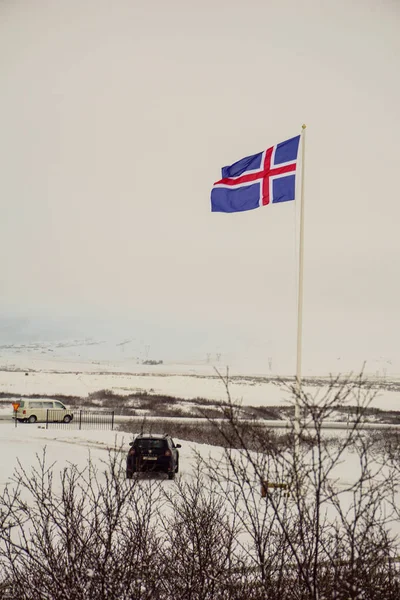 Η ισλανδική σημαία με τα αυτοκίνητα κοντά IT-τέλειο δείγμα εικόνας για ένα ταξίδι δρόμου μέσω της Ισλανδίας — Φωτογραφία Αρχείου