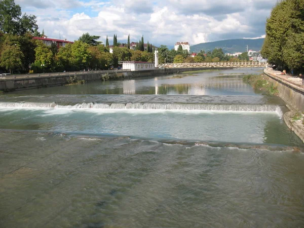 Река Сочи с мелкой водой и водопадом в солнечный день — стоковое фото