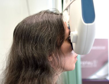 Genç ve güzel bir kadın otomatikleştirilmiş göz hekimliği donanımı ve düşük alan derinliği ile lens yerleştirme prosedürüne tabi tutuluyor.