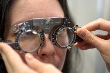 Genç ve güzel bir kadın vintage stil mercek testinde optometrist optometrist ile eşleşen çerçeve, düşük alan derinliği ile lens uyumu prosedürüne tabi tutuldu.