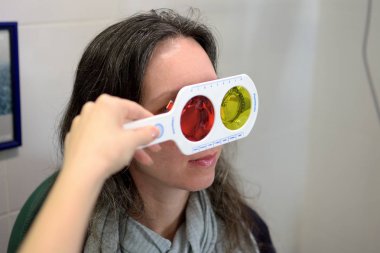 güzel genç kadın oftometrist oftalmolog optisyen bir renk körlüğü testi, alan düşük derinlik yapar