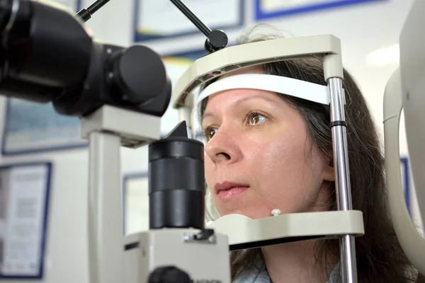 かなり若い女性は眼科医 被写界深度の低い眼底検査を受けた — ストック写真