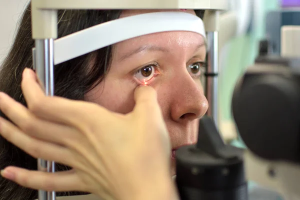 かなり若い女性は眼科医 被写界深度の低い眼底検査を受けた ストック写真