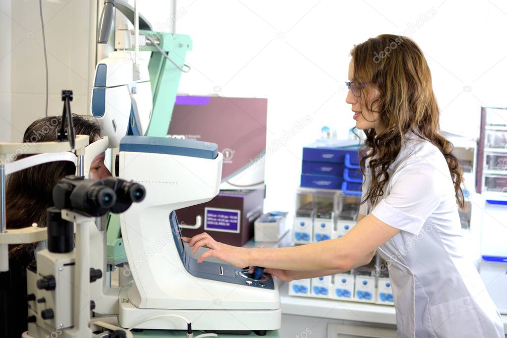 pretty young woman undergone an ocular fundus inspection with ophthalmologist optometrist optician, low depth of field