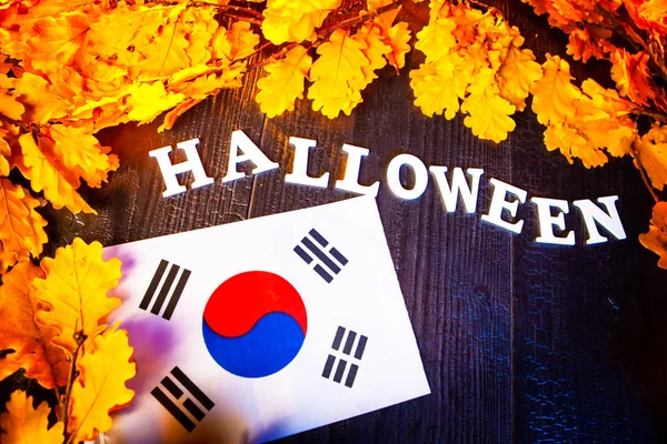 South Korean flag and the inscription Halloween. Halloween in South Korea. Toy bats. Flag of  South Korea surrounded with yellow oak leaves.