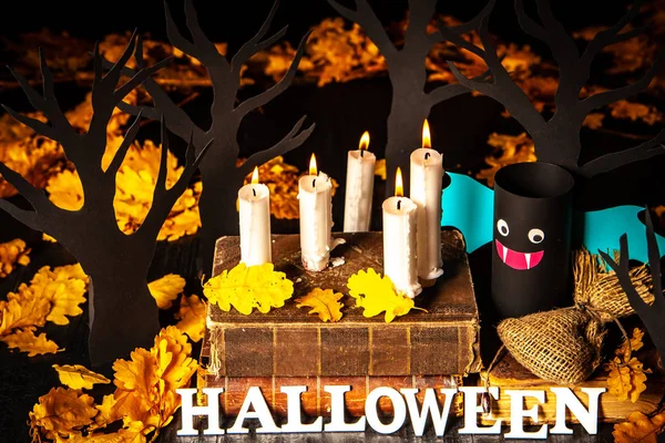 Holiday Halloween. Burning candles. Vampires against the background of yellow leaves. Decoration for the holiday Halloween. The inscription is Halloween.