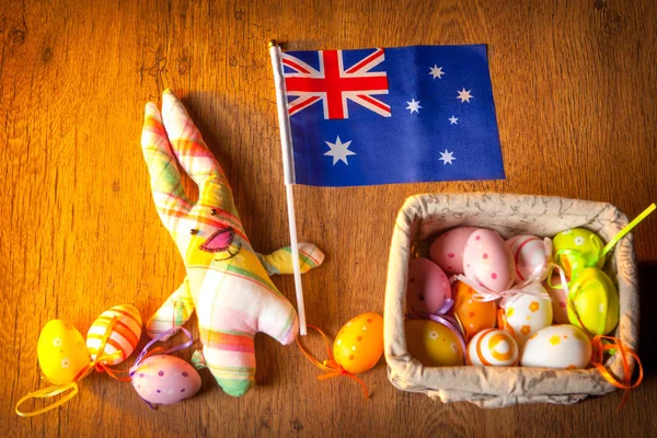 Easter holiday in Australia. The hare holds the flag of Australia. Easter eggs. Colored eggs for easter. Religious holiday in Australia. Easter.