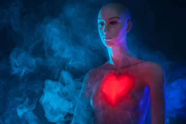 Burning heart. Heart on the human body. Mannequin woman. Silhouette of a woman.