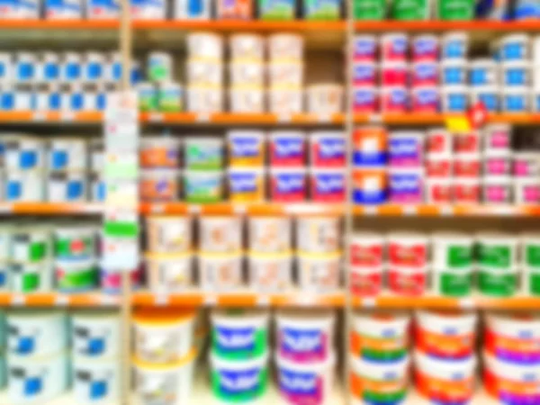 Blurred background. Shelves with goods. Sale of paint for repair. Sale of chemistry. Score. Hypermarket. Paint in cans on store shelves.