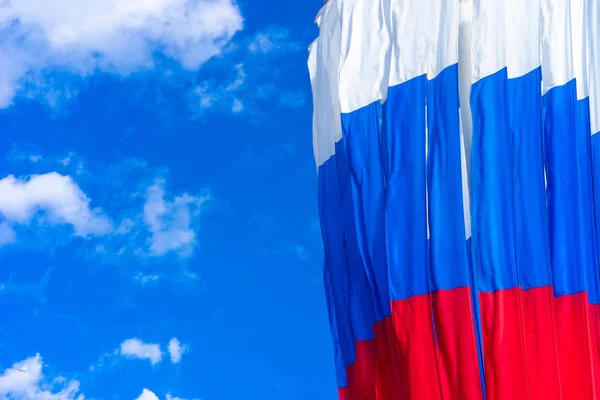 Flag of Russia. Flag of the Russian Federation against the blue sky. Red blue white flag.