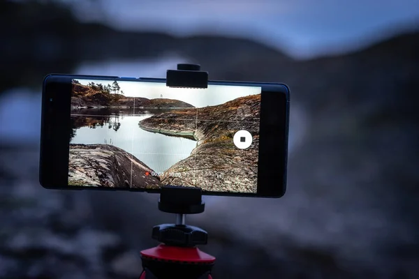 The phone is on a tripod. The phone shoots a video. Rocky shore. Photography of wild nature. Protocols between the islands. Journey to the wild.