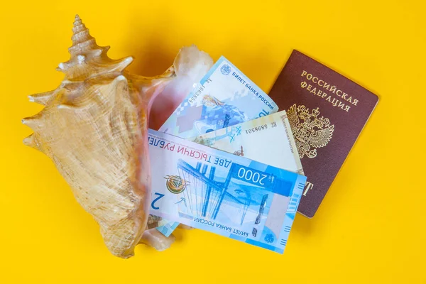 A trip to rest in Russia. Travels around Russia. Preparation for the Journey through Russia. Russian passport with money. Money and passport in the sea shell.