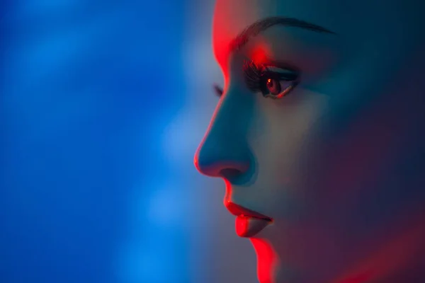 Portrait of a mannequin woman. Artificial face. Profile of a woman\'s face. The woman\'s face is in red light. Mannequin woman. Close-up portrait. Female profile.