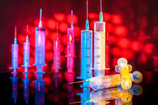 Syringes on the background of red bodies. Medical syringes. Syringes on the background of a drop of blood. Blood. Medical concept.