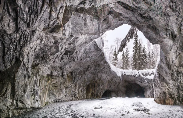 Cave in the rock. Winter landscape. Traveling in Russia. Winter cave. Grotto in the mountain.