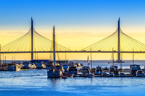 Pier with yachts. Yacht Club. The berth with the ships on the bridge background. The Gulf of Finland. Petersburg. Russia. Krestovsky Island.