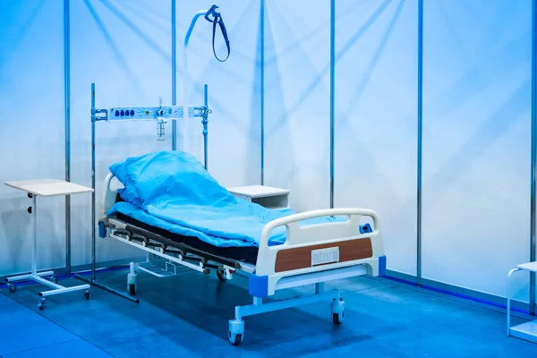 Hospital. Bed sick. Medical bed. Medical equipment. Medical bed with blue linens. Hospital bed on wheels.