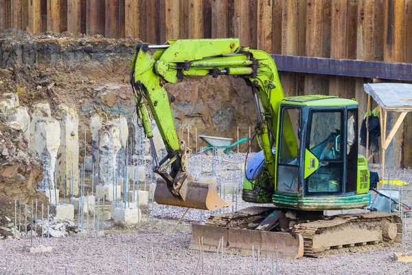 Foundation construction. Construction pit. Excavator with a bucket. Foundation blocks. Excavator aligns the ground.