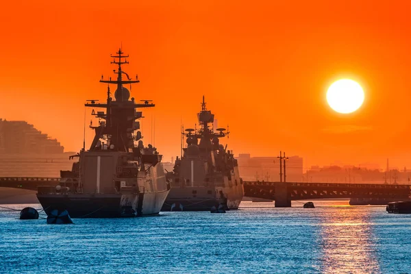 Caravan of warships. Military naval escort. Ships against the background of the sun.