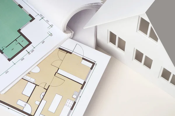 Drawings of the building on the desktop. Architectural company. Layout of the house with drawings. Development of a cottage construction plan. Apartment plan from the top. Desktop Architect.