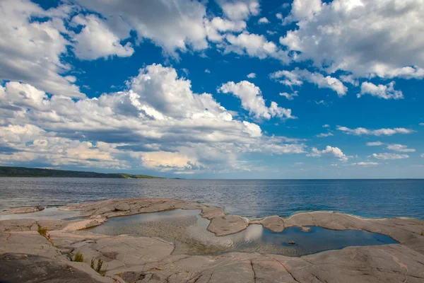 Island with stony shore. Island under the clouds. Karelia. Russia. Ladoga lake. — Stock Image Island with stony shore. Island under the clouds. Karelia. Russia. Ladoga lake. Stock Picture