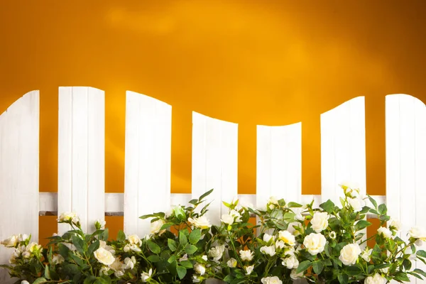 White fence decorated with flowers.