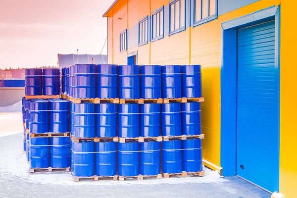 Blue containers palletized in stock. Plastic barrels for toxic p