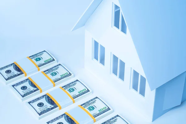 Housing loans. Miniature house with bundles of money. Accumulati
