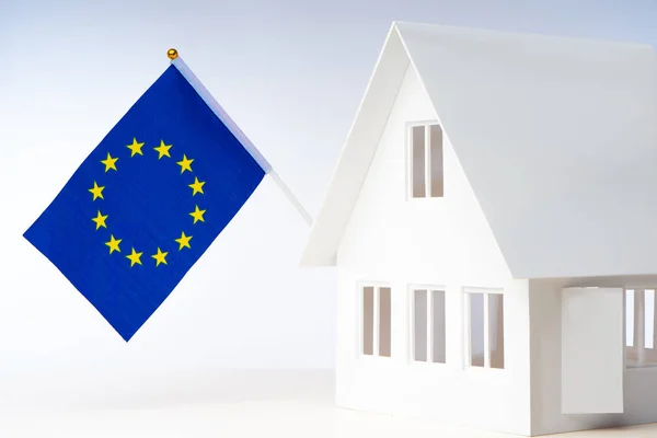 Immigration in Europe. Miniature house with the flag of the Euro