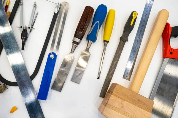 Carpentry tools on a white table. The working tools of a carpenter. Equipment carpentry. Woodworking. Furniture manufacturing.