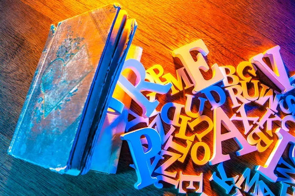 The letters of the English alphabet and a book on the table. Eng