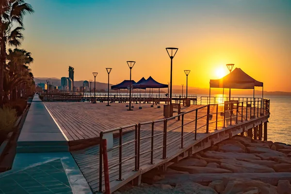 Sunset over the Mediterranean sea. View of the setting sun from the waterfront of Limassol. Evening view of Cyprus. Part of the promenade of Limassol for walking and relaxing with sea views. Molos
