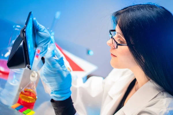 Laboratory cosmetics. A female laboratory assistant studies the