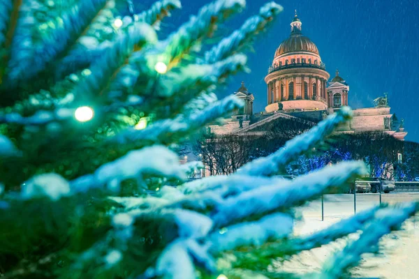 Winter in St. Petersburg. Russia. St. Isaac\'s Cathedral on the background of the Christmas tree and falling snow. New year. Christmas in Russia. Churches Of Petersburg. Waiting for the winter holiday