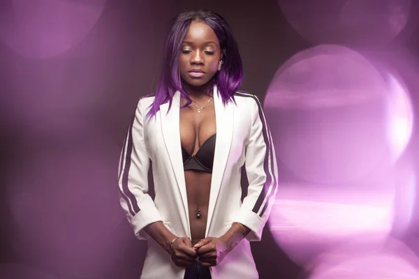 Dark-skinned model in a white jacket on a purple background. Afr