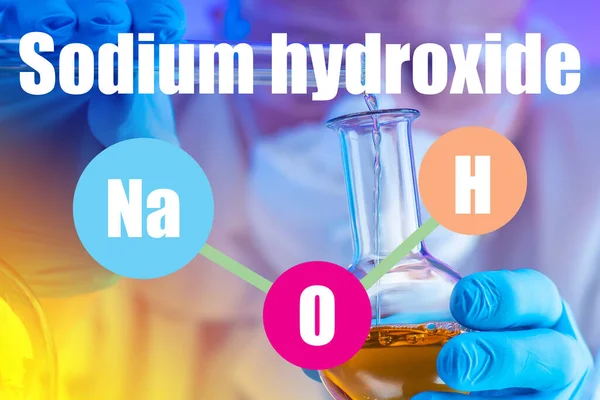 Logo NaOH. Inscription Sodium hydroxide on the background of the hands of a laboratory assistant. Test tube with liquid in the hands of a chemist. Concept - alkaline substances are in test tubes.
