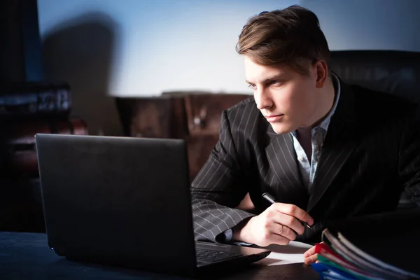 The man looks at the computer screen. The employee receives the necessary data via the Internet. A person is preparing a new project. Work with data. Design work. The boss is in his office.