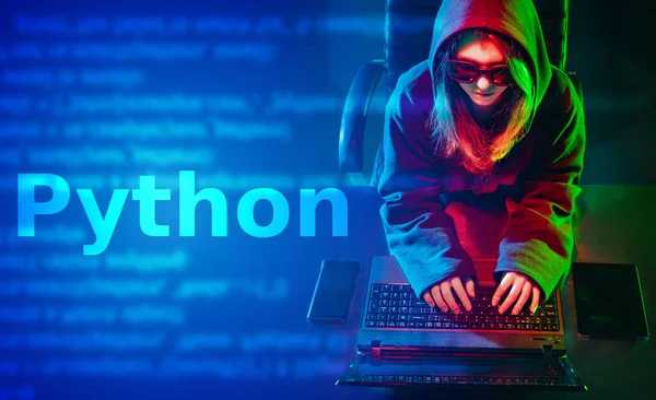 Python programming language. A long-haired girl in a hoodie writes a program in Python. Concept of programming languages. A woman develops software on Python.