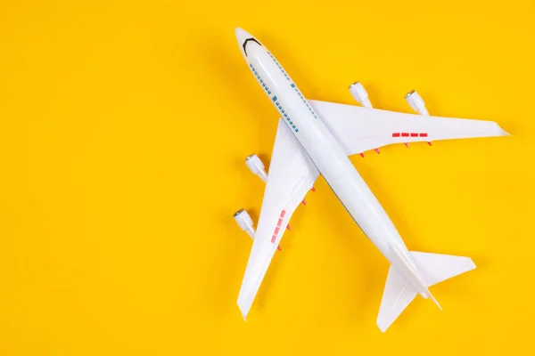 Airplane model. Large passenger plane top view. Two-story liner on a yellow background. Concept - travel by plane. Miniature airliner top view. Aeromodelling. Concept - Collecting Aircraft Models