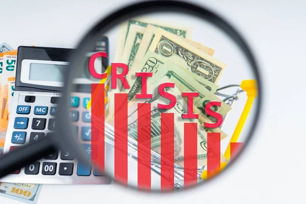 Economic crisis. Analysis of the economic situation in the world. The word Crisis, calculator, and banknotes are viewed under a magnifying glass. Problems in the world economy.