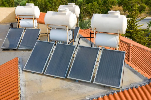 Solar panels for water heating. Solar panels and water canisters on the roof of the building. Using solar energy. Alternative energy source. Water heating for household needs.