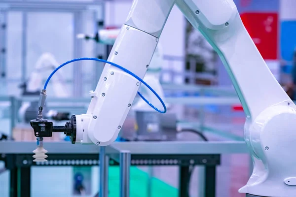 White industrial robot closeup. The robot arm manipulator with vacuum nozzle. Robot on the background of the research laboratory. Production automation. High-tech equipment.
