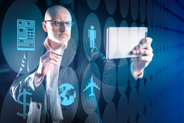 Logistic service. Man chooses a company that provides logistic service. Icons on virtual screen symbolize logistic service. Businessman holds tablet in front of him. His looking for transport company