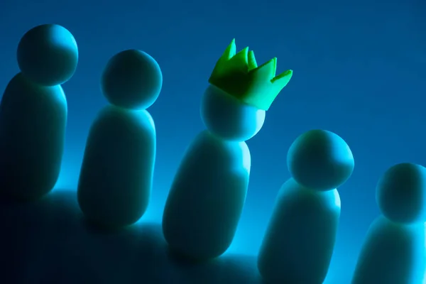 CEO. White figures of people on dark blue background. Little man in crown symbolizes high valence. Employee holds managerial position in company. Personnel Management. Business concept. CEO company