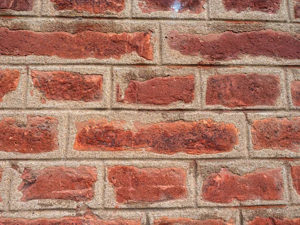 Brickwork close-up. Brick and cement wall. The bricks are cemented together. Geometric pattern on the brown wall.